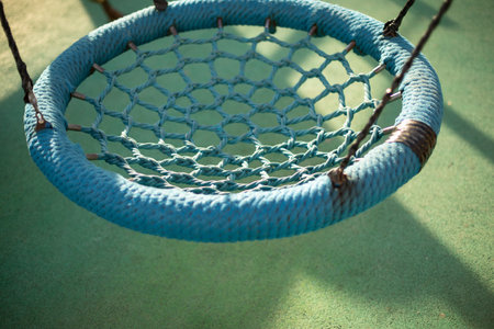 Children's swings of round shape. Rope swings. Children's playground in yard.の写真素材