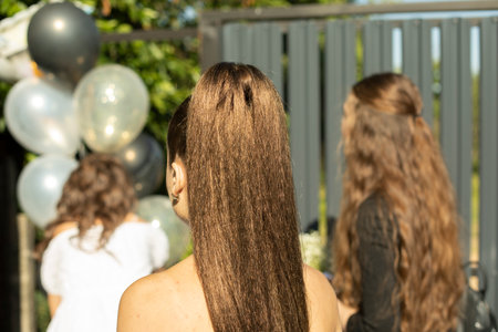 Styling girl's hair. long brunette hair. beautiful girl from back. wedding guests.の写真素材