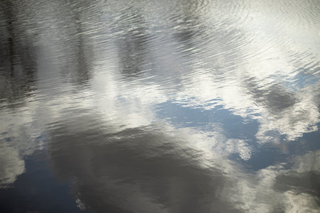 texture of water. Reflection of clouds in water. Ripples on the lake. Details of nature in summer.
