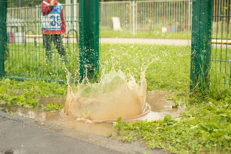 Splashes in puddle. Child threw stone into puddle.の写真素材