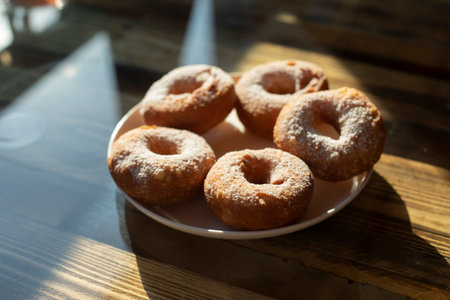 Donuts with powdered sugar. Delicious food in light of the sun. sweet tea. food on table.の写真素材