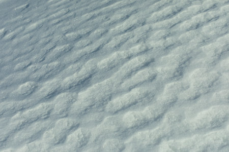 Texture of snow. Melted snow in winter in sun. Surface is wavy. Details of winter.の写真素材