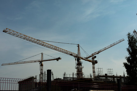 Construction crane against sky. Construction site view. Industrial construction. High-altitude equipment. Construction of structure.の写真素材