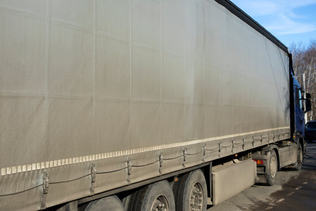 Truck with trailer. Gray awning on truck body. Transport side view. Car on road. Transportation of goods.の写真素材