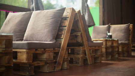 Soft sitting in restaurant. Comfortable seating for guests. Craft furniture. Soft pillow. Simple interior.の写真素材