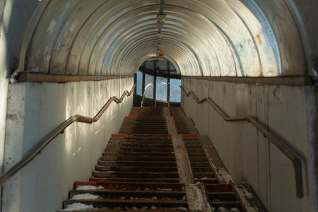 Stairs in city. Tunnel to top. Steps in snow. Pedestrian crossing over highway.の写真素材