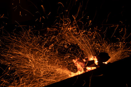 Burning firewood. Sparks from coals. Burning wood. Small sparks.の写真素材
