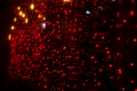 Red garlands on glass. interior details. Window garland decoration. Lights in dark.の写真素材