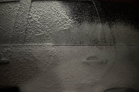 Washing car. Car in car wash. Foam on transport. Soapy solution.の写真素材