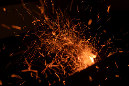 Sparks from Fire. Sparks on a black background. The combustion process. Flames in the dark.の写真素材