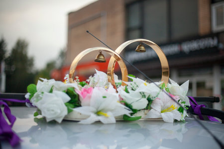 Wedding rings on the roof of the car. Festive decoration of transport. Newlyweds' car. Gold Rings on the Roof.の写真素材