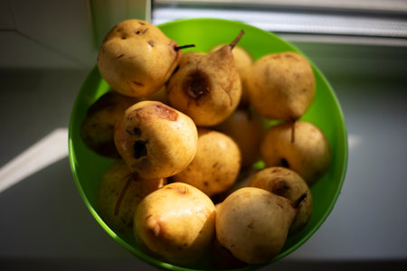 Pear in a plate. Fruit in the kitchen. Eating at home. Useful fruits. Pears in a plate on the window.の写真素材