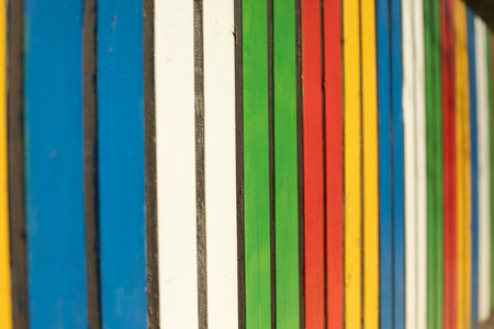 Colored fence. Beautiful fence. Different color on boards. Painted material. Design Details.の写真素材