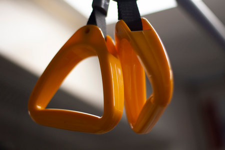 Handrail in the bus. Handrail for the hand in transport. Yellow handle on the belt. Details of the interior of the bus.の写真素材