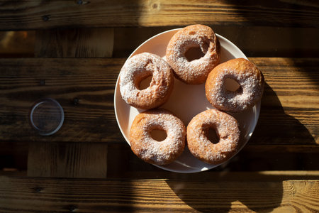 Fried donuts on table. sweet food. Powdered sugar on baking. Plate of treats.の写真素材
