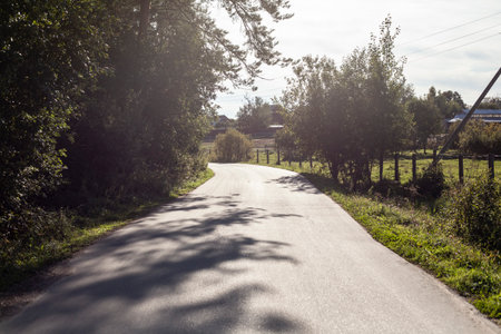 The Road to the Farm. Highway in the countryside. Narrow road in summer. A sunny day on an empty road.の写真素材