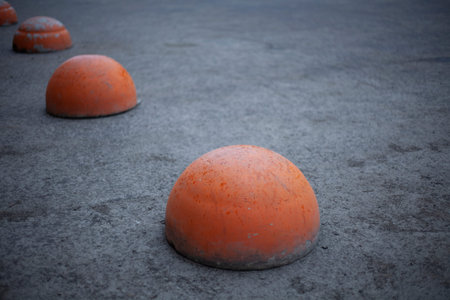 Sphere in the parking lot. Motion limiter. Orange sphere on asphalt. Parking in detail.の写真素材