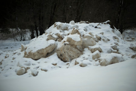 Dirty snow by road. Side of road in winter. Blocks of ice are black. Snow dump.
