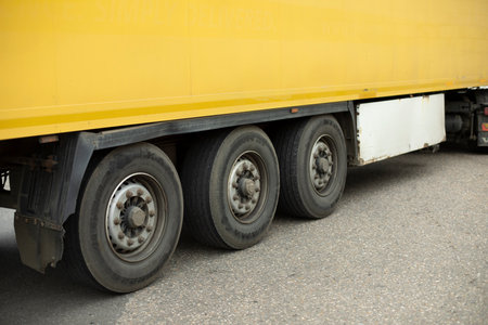 Wheels of truck. Large trailer wheels. Yellow truck trailer. Transport details.の写真素材