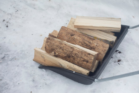 Firewood for heating in winter. Transportation of firewood. Chopped wood. Convenient transport of firewood in snow.の写真素材