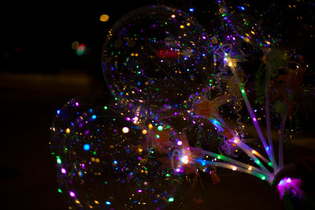 Balloons with lights. Garlands in dark. Glowing light bulbs inside empty balls. Fun item.の写真素材