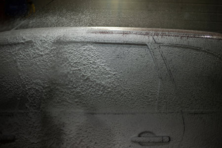 Washing car. Car in car wash. Foam on transport. Soapy solution.の写真素材