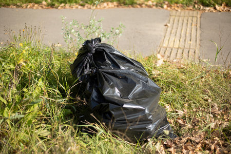 Garbage bag. Black Waste Bag. Waste disposal. Bag in the park.の写真素材