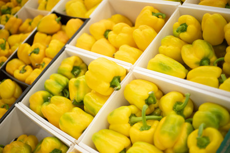 Yellow pepper on the counter. Sale of vegetables. Pepper in a box. Vegetables at the market.の写真素材