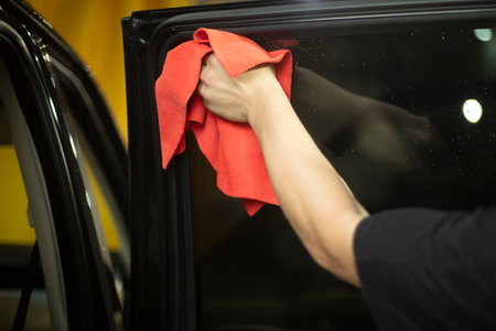 Car wiping. Washing Dust Off Machine Glass. Red rag in hand. Car Washer Job.の写真素材