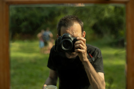 Photographer shoots himself in mirror. Professional reporter takes self-portrait. Amateur with...