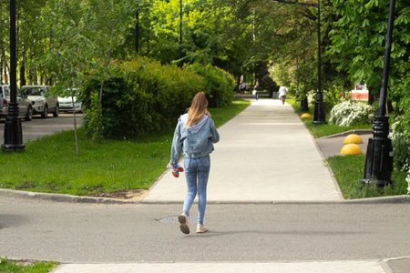 Girl is on the road. Girl walks around city. Details of walk. Life in city in summer.の写真素材