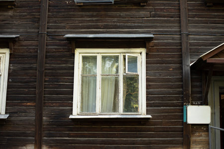 Window in old house made of boards. House of 20s. Old architecture. Wooden window frame.の写真素材