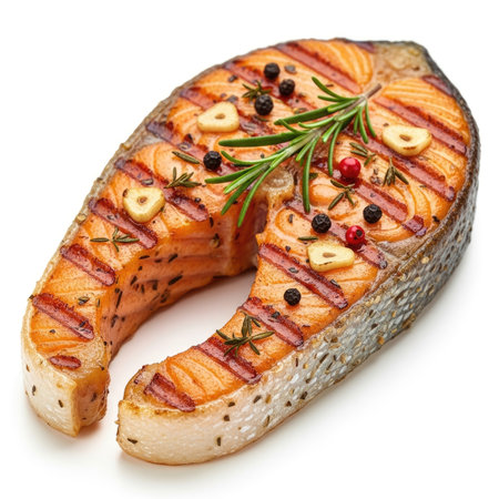 A perfectly grilled salmon steak seasoned with herbs, garlic, and peppercorns, presented on a white background.の素材