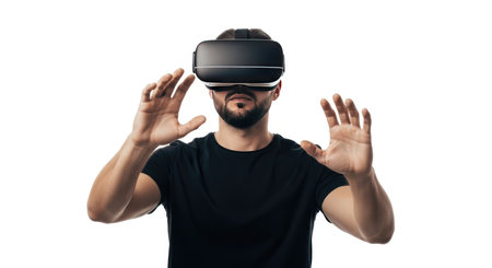A man with a beard wears a black VR headset and black t-shirt, reaching out with both hands, immersed in a virtual world.の素材