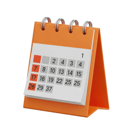 A small, orange desk calendar stands open, showing a grid of dates and days of the week on its pages.の素材