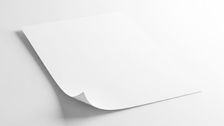 This image features a single sheet of white paper with a slight curl at one corner. The paper is illuminated by a soft light source from the left, casting a subtle shadow on the right side. The background is a plain, light gray color, providing a neutral backdrop that emphasizes the paper and its shadow.の素材