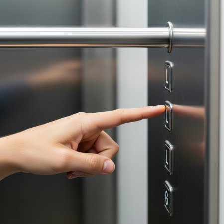 A close-up image of a hand pressing a button on an elevator control panel, with the focus on the action of selecting a floor.の素材