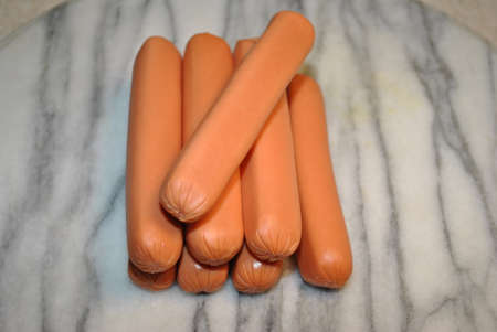 Raw Hotdogs on a Marble Cutting Boardの写真素材