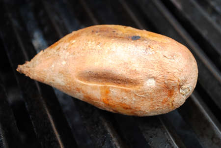Fresh Whole Sweet Potato Cooking on a Grillの写真素材