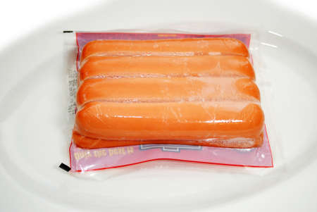 Thawing Frozen Packaged Hotdogs on a Plateの写真素材
