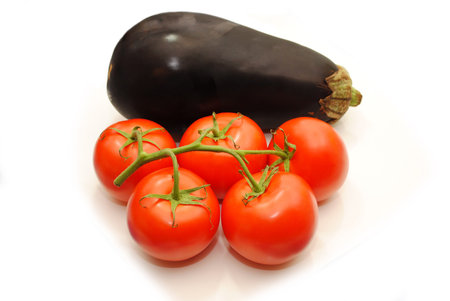 Five Tomatoes on a Vine with a Whole Egplantの写真素材