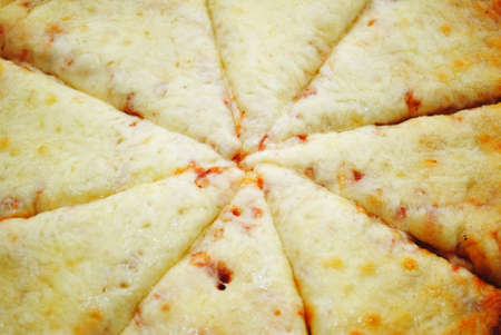 Close-Up of the Center of a Sliced Cheesy Pizzaの写真素材