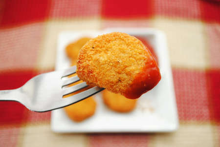 Eating a Fish or Chicken Nugget From a Forkの写真素材