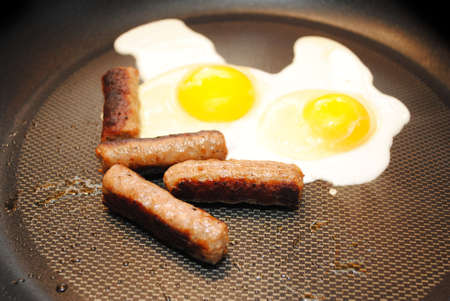 Cooking Two Sunny Side Up Eggs with Sausageの写真素材
