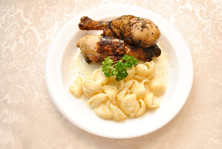 Baked Chicken Leg Dinner Served with Creamy White Cheddar Macaroni and Cheeseの写真素材