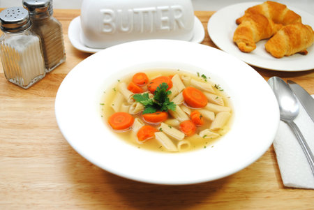 Vegan Penne Vegetable Soup Served in a White Bowlの写真素材