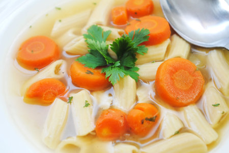 Vegan Penne Vegetable Soup Served in a White Bowlの写真素材