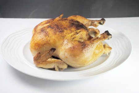 Whole Roasted Chicken on a Round White Platterの写真素材