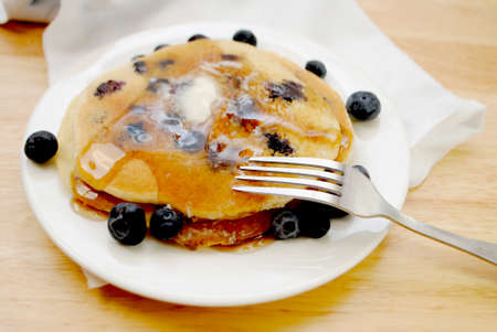 Eating Blueberry Pancakes Coved with Butter and Syrupの写真素材