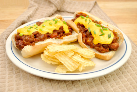 Loaded Chili Dog with Cheddar Cheese and Scallion Served with Wavy Potato Chipsの写真素材